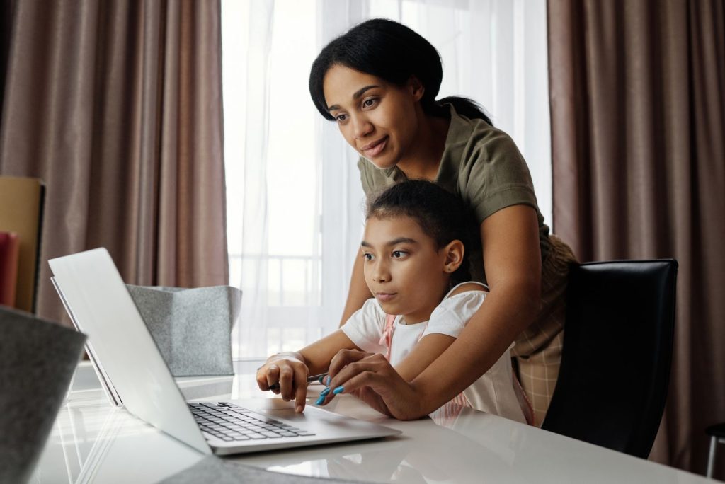 Parent accompagnant un enfant devant un ordinateur